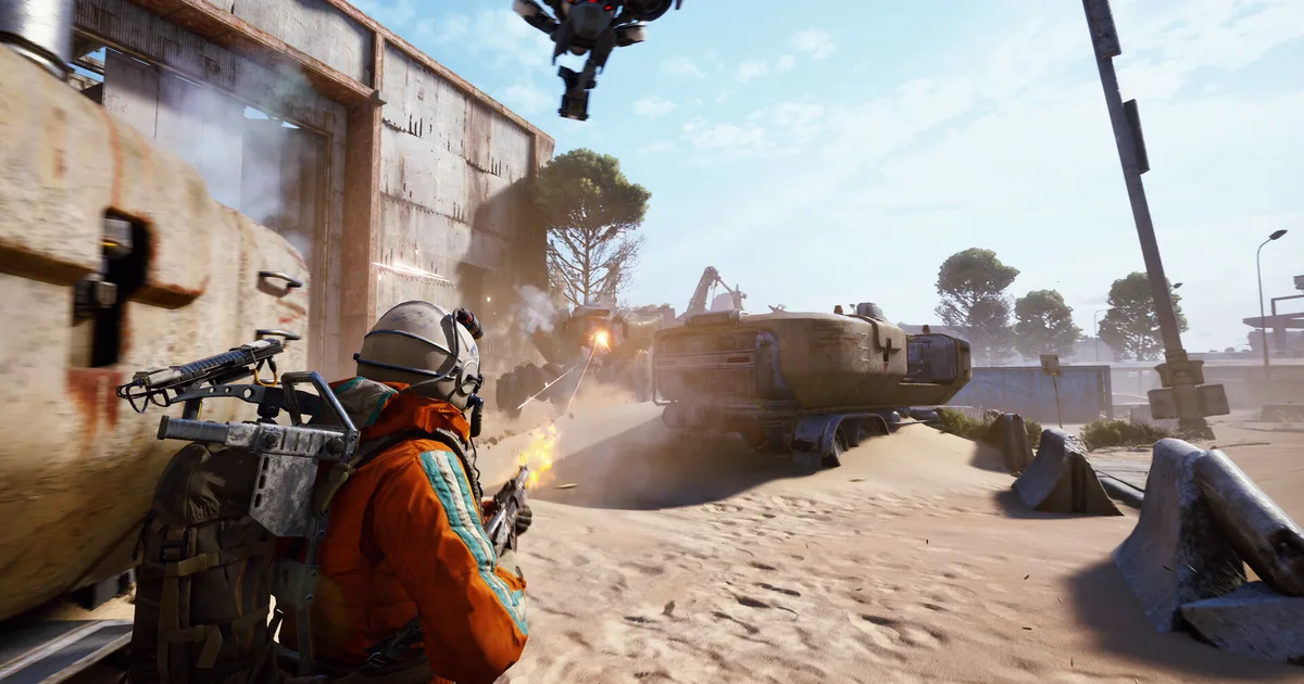 ARC Raiders raider in orange suit taking cover at desert ruins while ARC machine advances, sandy wasteland with overturned vehicles